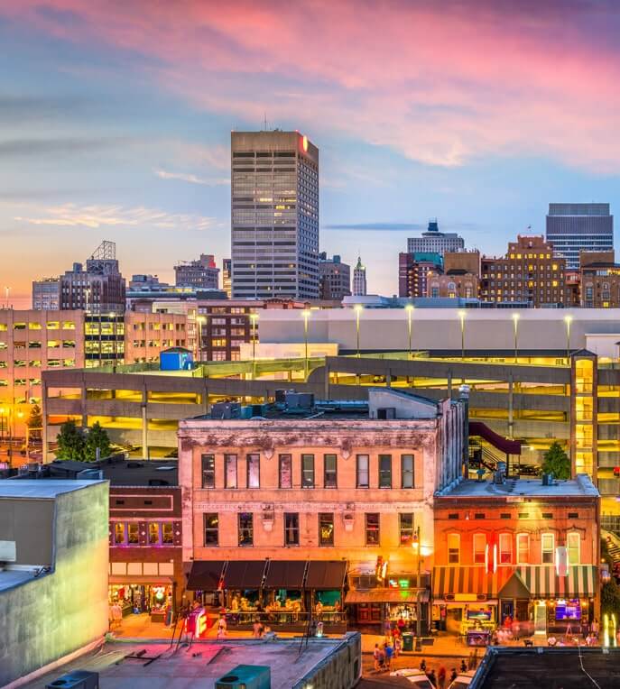 Image of the Memphis skyline against a pink/blue sunset sky